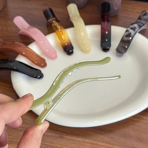 Jelly texture duckbill hair clips in various colors arranged on a white ceramic plate