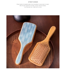 Detail of wooden cushion hairbrushes featuring blue and white marble acetate finish