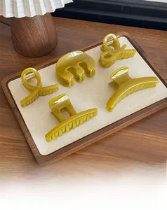 Dettaglio di diverse mollette per capelli verde oliva in varie forme geometriche