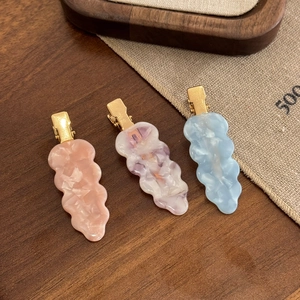 Three-piece set of wavy acetate hair clips in pastel pink orange purple and blue colors