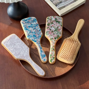 Elegant cellulose acetate paddle hair brushes with wooden handles and colorful marble patterns