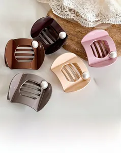 Detailed view of matte geometric shark hair claws with large pearl accents in five colors