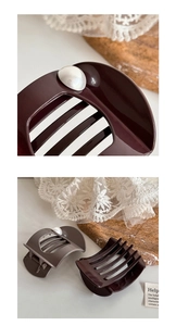 Detail of glossy large hair claws in brown and grey with elegant white pearl accents