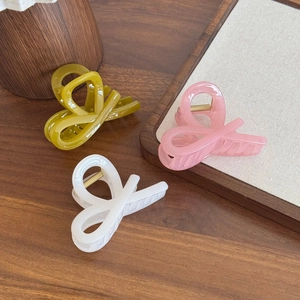 Tre eleganti mollette per capelli in giallo rosa e bianco con finitura lucida su legno