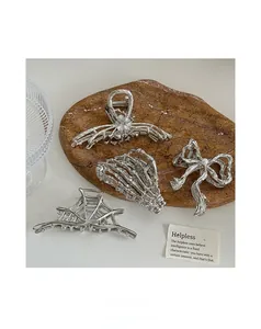 Detail of silver alloy ribbon bow hair claw clips with gothic spider web and skull motifs