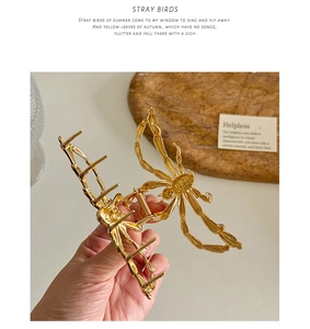 Close-up of golden metal spider hair claw clip with detailed legs and strong grip teeth