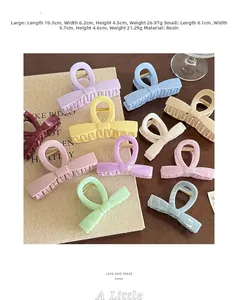 Colorful bow hair claw clips in large and small sizes displayed on a wooden surface