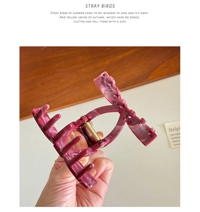 Detail view of large marble texture hair claw clip in deep purple with gold spring