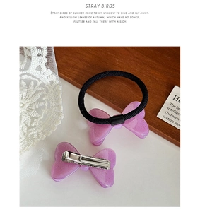 Détail d'un nœud papillon violet scintillant et d'un élastique sur dentelle et bois