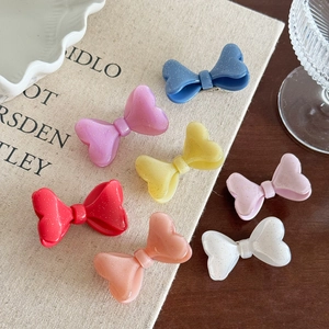 Lot de sept pinces à cheveux en résine pailletée aux couleurs acidulées sur fond de toile