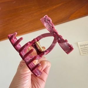 Handheld butterfly hair claw clip with purple marble pattern and gold metal spring