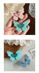 Detailed macro view of matte resin butterfly hair clip with LOVE heart and rhinestones