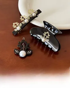 Close-up of black pearl reindeer hair clips set on a rustic wooden tabletop