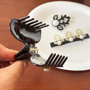 Elegant black acetate hair claw clip set with pearls and gold leaf accents