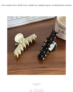 Detailed view of floral acetate hair claw clips with pearls on a wooden surface