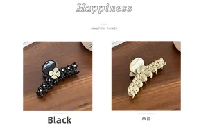 Detailed view of acetate flower hair claws with pearls in black and cream white colors