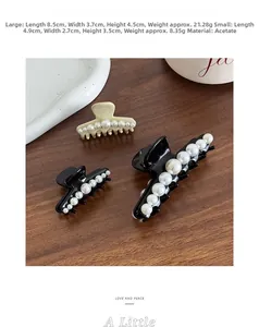 Close-up of elegant acetate hair claw clips with gradient pearls on a wooden surface