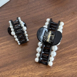 French style elegant black pearl hair claw clips in two sizes on wooden background