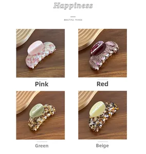 Detail view of large acetate claw clips in marble and tortoiseshell patterns in four colors