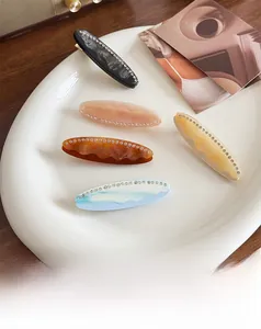 Lot de cinq élégantes barrettes en acétate avec strass en plusieurs couleurs sur plateau