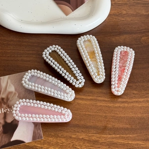 5-piece pearl hair clip set with marble texture and acetate resin base on wood background