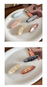 Détail de barrettes en acétate marbré avec des strass étincelants en plusieurs couleurs