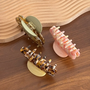 Three premium acetate shark hair clips in assorted leopard and marble patterns for women