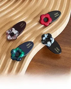 Close-up of four floral acetate hair clips on a wooden tray with gold handmade lettering