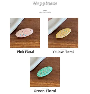 Detailed macro view of acetate hair clips with colorful rhinestones and floral textures