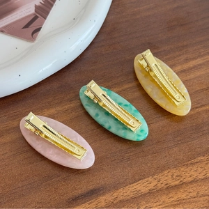 Elegant oval acetate hair clips with colorful marble textures and metal duckbill clamps