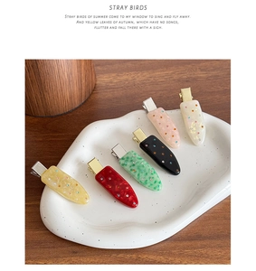 Detail showing colorful rhinestones on acetate hair clips in six vibrant colors
