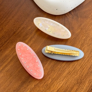 Elegant jelly color marble hair clips with sparkling crystals on dark wooden surface