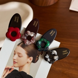 Chic floral acetate hair clips in assorted colors clipped on a magazine for styling