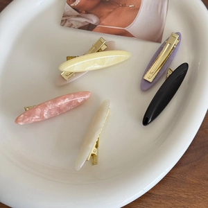 Set of 5 minimalist acetate duckbill hair clips in marble colors on a ceramic tray