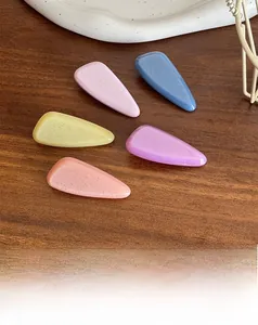 Close-up of teardrop hair clips in candy colors with glitter finish on wood