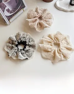 Vue détaillée de trois chouchous en dentelle à couches en rose, blanc et motifs fleurs