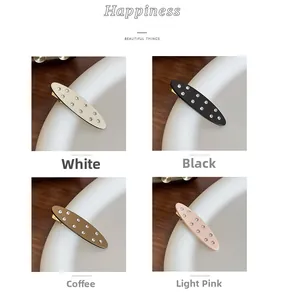 Detailed view of four acetate hair clips with rhinestones in white, black, coffee, and pink