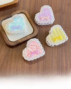 Close-up of heart-shaped hair claw clips with bows in pastel blue, purple, yellow, and pink