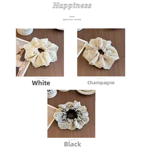 Détail de chouchous en dentelle à quatre couches en blanc et champagne sur un bureau
