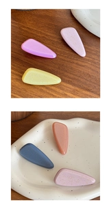 Macro detail of tear-drop hair clips with fine glitter finish in macaron colors