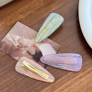 Three-piece colorful acetate drop hair clips with vibrant stripes and gold metal base