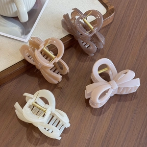 Set of four jelly-colored bow hair claws in dark coffee, apricot, pink, and cream