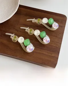 Gros plan détaillé de barrettes en résine avec fleurs séchées et accents de feuilles d'or