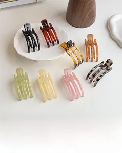 Close-up of minimalist resin hair claws in assorted jelly colors on a decorative tray