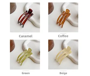 Detail view of four semi-transparent hair clips in caramel, coffee, green, and beige colors