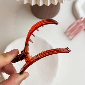 Minimalist amber red jelly hair claw clip for bun styling with glossy acrylic finish