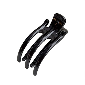 Minimalist glossy black hair claw clip with multi-tooth curved design on white background