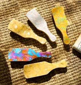 Detail of five geometric acetate hair clips with marble texture on woven straw mat