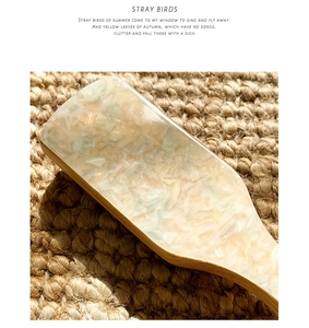 Detail view of the wooden anti-static hair brush with elegant pearlescent shell texture