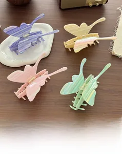 Close-up of four oversized acetate butterfly hair claws in pastel marble textures